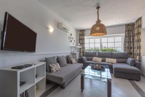 salon z kanapą i telewizorem z płaskim ekranem w obiekcie Villa del Sol - Entre Tu y Yo w mieście Benalmádena