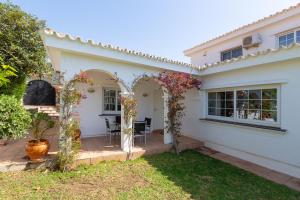 Biały dom z łukiem i ogródkiem w obiekcie Villa del Sol - Entre Tu y Yo w mieście Benalmádena