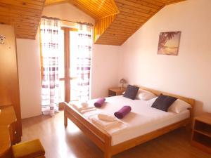 ein Schlafzimmer mit einem Bett und einem großen Fenster in der Unterkunft Apartments Sponga in Polače