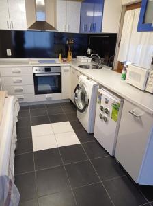 a kitchen with a washing machine and a sink at Chergata Guest House in Zheglitsa