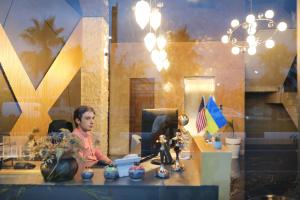 a man sitting at a desk in front of a computer at Bessarion Boutique Hotel in Kutaisi