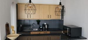 a kitchen with black counter tops and wooden cabinets at Albatros Tenerife Golf Sea View in San Miguel de Abona