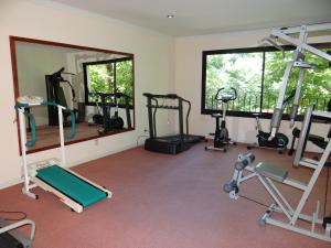 - une salle de sport avec plusieurs tapis de course et un miroir dans l'établissement Hotel Italiano, à Colonia del Sacramento