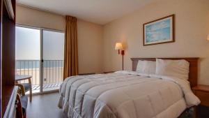a hotel room with a bed and a large window at Ocean 1 Hotel & Suites Ocean City in Ocean City