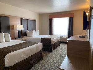 a hotel room with two beds and a television at Gold Circle Inn in Lloydminster