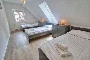 a attic bedroom with two beds and a window at AUžlak hiša, apartments. in Luče