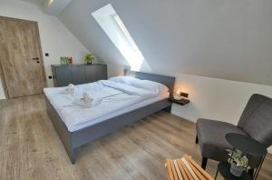 1 dormitorio pequeño con 1 cama y 1 silla en AUžlak hiša, apartments. en Luče
