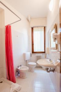 a bathroom with a red shower curtain and a toilet and sink at Hotel Villa del Mare in Senigallia +44 photos