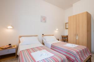 a bedroom with two beds and a cabinet at Hotel Villa del Mare in Senigallia