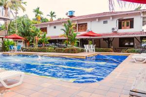 a swimming pool in front of a house at Hotel Casa Baquero in Villavicencio