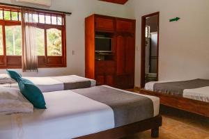 een slaapkamer met twee bedden en een raam bij Hotel Casa Baquero in Villavicencio