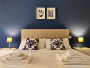 a bedroom with a bed with blue walls and two lamps at Elpida Apartment Reggio Calabria in Reggio di Calabria