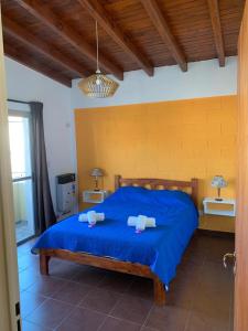 a bedroom with a blue bed with two towels on it at Departamentos Monteolivos in Merlo