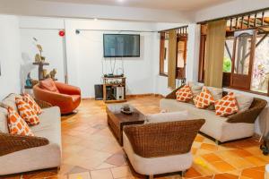 a living room with couches and chairs and a television at Hotel Casa Baquero in Villavicencio