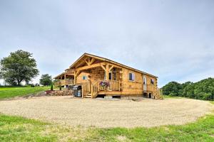 une cabane en rondins avec une véranda et une terrasse dans l'établissement Quiet Farmhouse-Style Cabin with Front Porch!, 