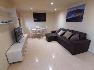 Apartamento Pirulana Bajo في فيستيرا: غرفة معيشة مع أريكة سوداء وطاولة