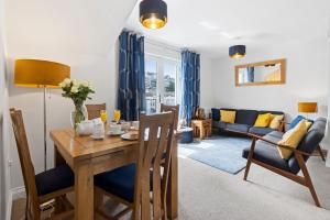 a dining room and living room with a table and chairs at A modern and cosy apartment just yards from Brixham’s bustling harbourside in Brixham