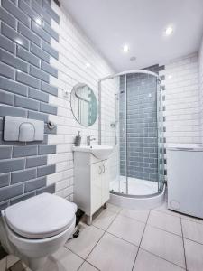 a bathroom with a toilet and a sink and a shower at Chill House in Mrągowo