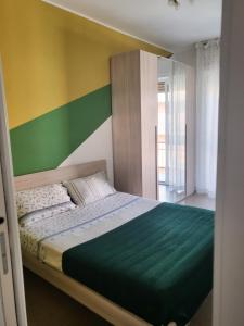1 dormitorio con 1 cama con pared verde y amarilla en Albenga House, en Albenga