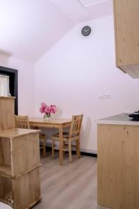 uma cozinha com uma mesa e cadeiras de madeira e uma mesa em Birtok Houses- twin no 1 for 2 people em Borzont