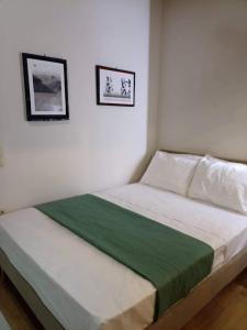 een bed in een slaapkamer met twee foto's aan de muur bij Angel's Houses in Skala Kallonis