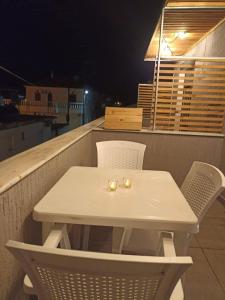 a white table and chairs on a balcony at night at Angel's Houses in Skala Kallonis
