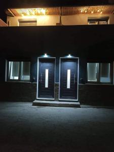 een paar deuren op een gebouw 's nachts bij Angel's Houses in Skala Kallonis
