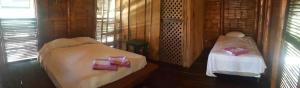 Eco-Hotel Playa Quilombo في Las Lisas: غرفة بسريرين في كابينة خشبية