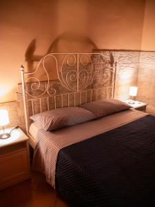 ein Schlafzimmer mit einem großen Bett mit einem Kopfteil aus Metall in der Unterkunft Il Gelsomineto dell'Etna in Nicolosi