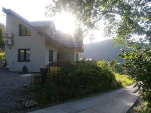 une maison blanche avec le soleil brillant derrière elle dans l'établissement Ski House Szczyrk - Czyrna, à Szczyrk
