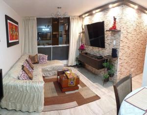 a living room with a couch and a television at Dpto entero, 2do piso, ascensor, jacuzzi y cochera in Lima