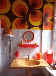 a bathroom with a sink and a colorful wall at Vintage ,le paradis des enfants wifi draps parking free in Thiers