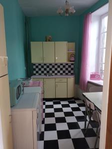 a kitchen with a black and white checkered floor at Vintage ,le paradis des enfants wifi draps parking free in Thiers