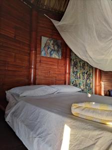 a bedroom with a bed with a wooden head board at Eco-Hotel Playa Quilombo in Las Lisas