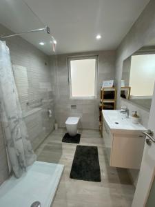 a bathroom with two sinks and a toilet and a shower at Modern Apartment with Large Outdoor Area - Sleeps 7, Close to Malta International Airport in Luqa