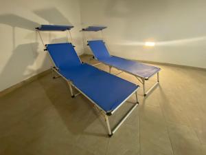 trois chaises bleues sont assises dans une pièce dans l'établissement Modern Apartment with Large Outdoor Area - Sleeps 7, Close to Malta International Airport, à Ħal Luqa