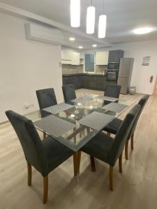 een eettafel en stoelen in een keuken bij Modern Apartment with Large Outdoor Area - Sleeps 7, Close to Malta International Airport in Luqa