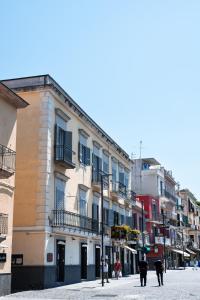 un grupo de personas caminando por una calle con edificios en Centro Storico Bed e Breakfast en Pozzuoli