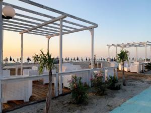 een uitzicht op een strand met witte stoelen en parasols bij Pansini Hotel Residence in Badolato