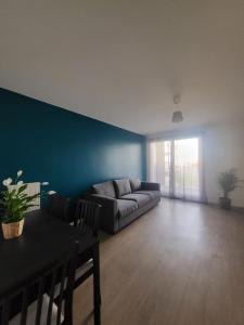 a living room with a couch and a table at Logement La courneuve-Aubervilliers RerB in La Courneuve