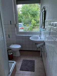 ein Bad mit einem WC, einem Waschbecken und einem Fenster in der Unterkunft Seeblick Bungalow in Arendsee