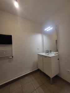 biała łazienka z umywalką i lustrem w obiekcie Logement La courneuve-Aubervilliers RerB w mieście La Courneuve