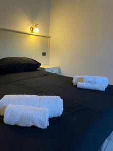 Una cama con dos toallas blancas encima. en Oz House, en Scalea
