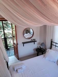 1 dormitorio con 1 cama grande y espejo en Liakoto, en Panayia