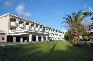 duży biały budynek z palmą przed nim w obiekcie Bahia Plaza Hotel w mieście Busca-Vida