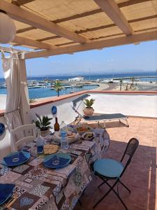 stół z jedzeniem i widokiem na ocean w obiekcie Perla del mare w mieście Calasetta