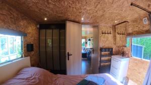 um quarto com uma cama e um lavatório num quarto em Le Cottage des Hortillonnages em Amiens