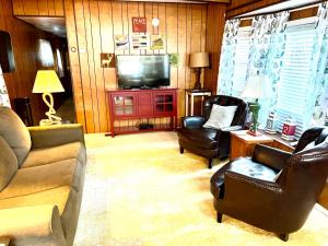a living room with a couch and chairs and a television at White Caps Motel in Port Clinton