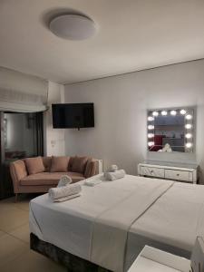 ein Schlafzimmer mit einem großen Bett und einem Sofa in der Unterkunft COZIDEA apartments CHALKIDA in Chalkida