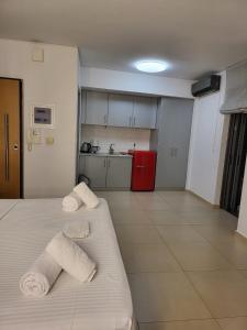 ein Zimmer mit 2 Handtüchern auf einem Bett und einer Küche in der Unterkunft COZIDEA apartments CHALKIDA in Chalkida
